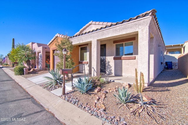 view of front of house featuring a tile roof and stucco siding