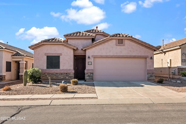 mediterranean / spanish-style house with stone siding, a tiled roof, an attached garage, concrete driveway, and stucco siding