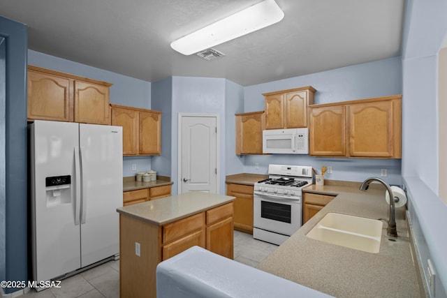 kitchen with light tile patterned floors, white appliances, a sink, visible vents, and a center island