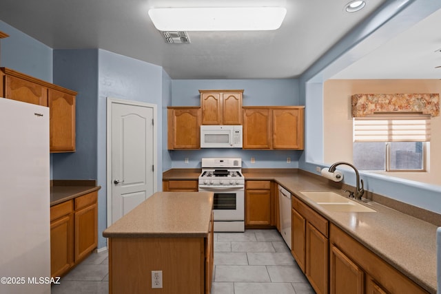 kitchen with light tile patterned flooring, a sink, a kitchen island, white appliances, and visible vents