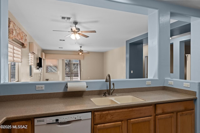kitchen with visible vents, a ceiling fan, a sink, dishwashing machine, and brown cabinetry
