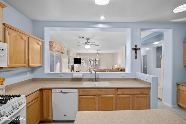 kitchen with light tile patterned floors, light countertops, visible vents, a sink, and white appliances