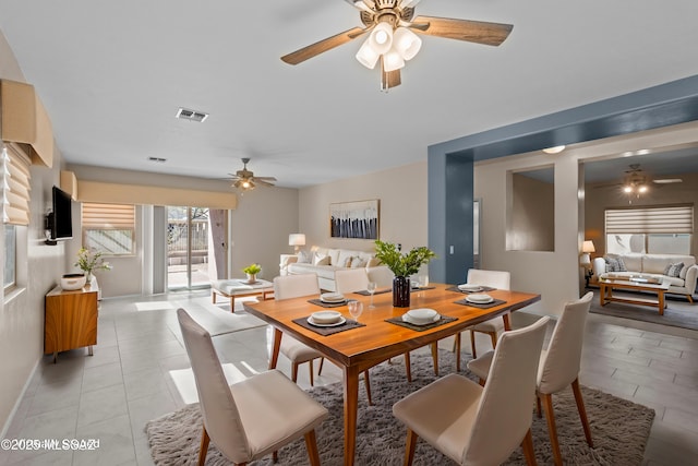 dining area featuring baseboards, ceiling fan, visible vents, and light tile patterned floors