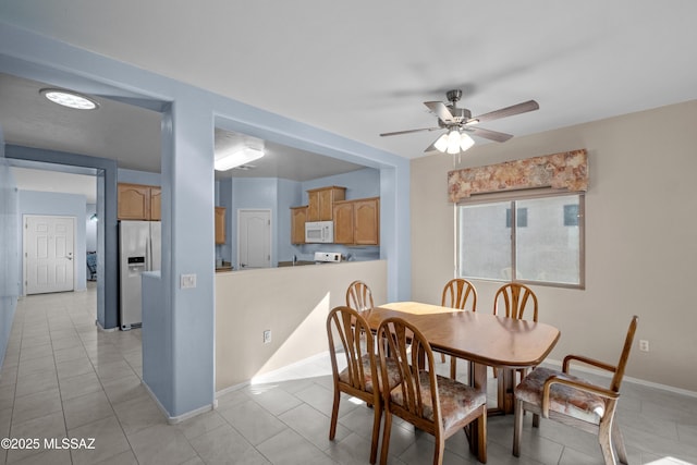 dining space with light tile patterned floors, ceiling fan, and baseboards