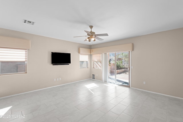 empty room featuring baseboards, light tile patterned floors, visible vents, and a ceiling fan