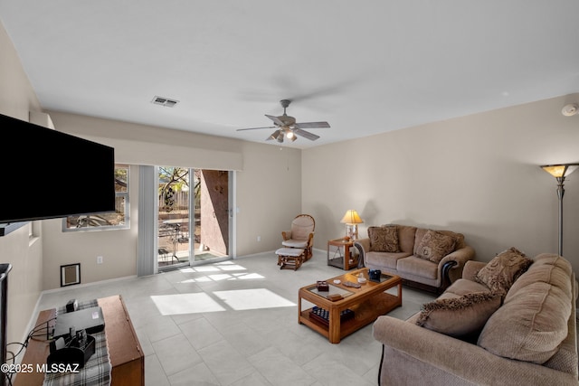 living room with visible vents, baseboards, and a ceiling fan