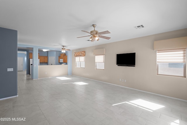 unfurnished living room with baseboards, visible vents, and a ceiling fan