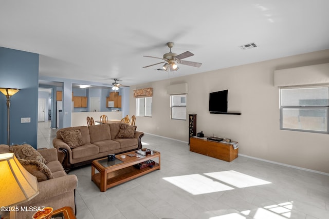 living room featuring visible vents, ceiling fan, and baseboards