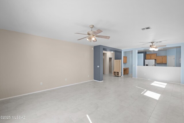 unfurnished living room with baseboards, visible vents, and ceiling fan