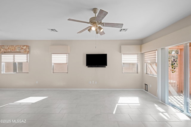 spare room with light tile patterned flooring, baseboards, ceiling fan, and visible vents