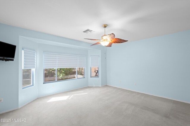 spare room with visible vents, ceiling fan, and carpet flooring