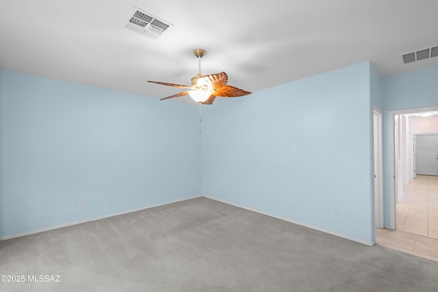 unfurnished room with visible vents, a ceiling fan, and light colored carpet