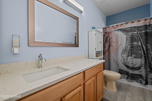 full bath with toilet, a shower with curtain, wood finished floors, and vanity