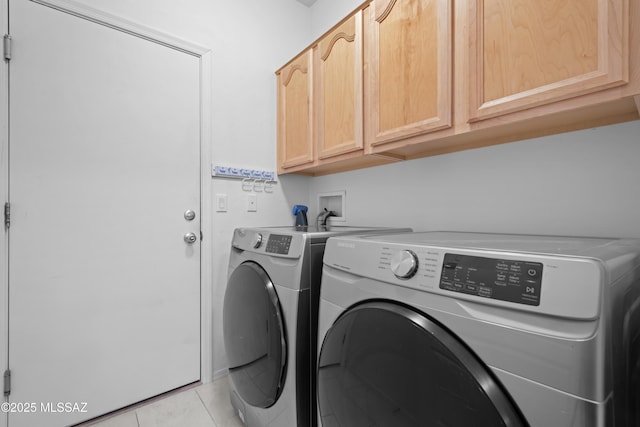washroom featuring light tile patterned floors, cabinet space, and washer and dryer