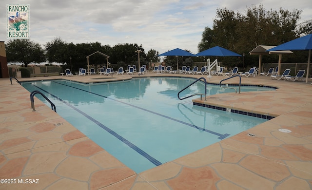 pool featuring fence and a patio