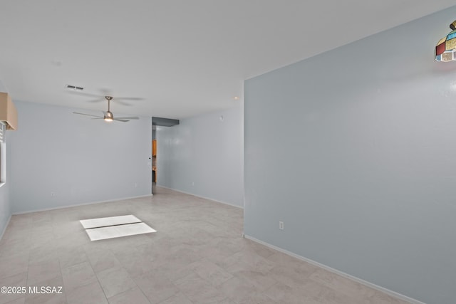 unfurnished room with baseboards, visible vents, and a ceiling fan