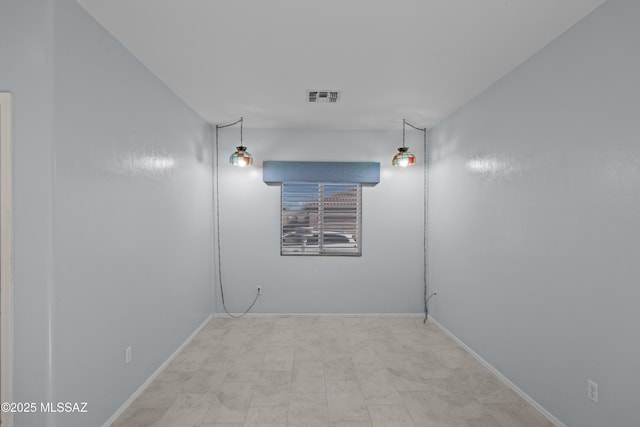 spare room featuring baseboards and visible vents
