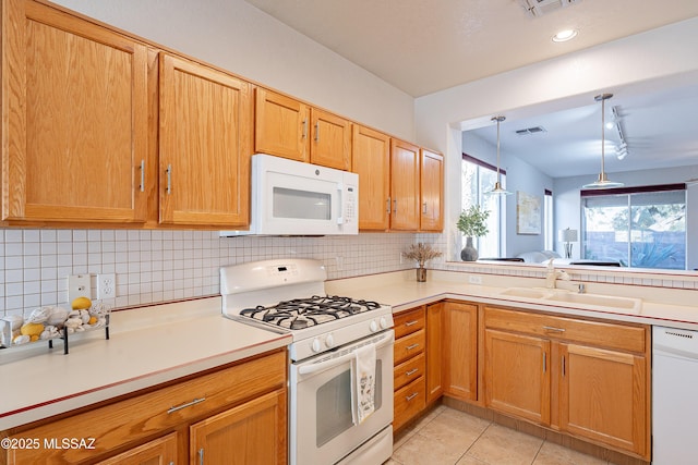 kitchen with visible vents, backsplash, light tile patterned floors, white appliances, and a sink