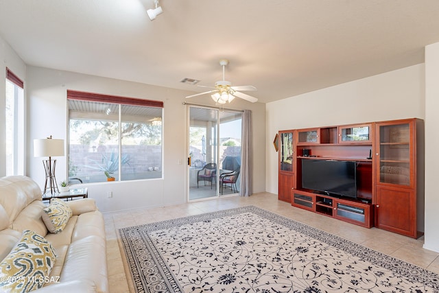 living room with light tile patterned floors, visible vents, and a ceiling fan