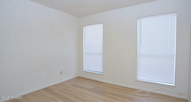 empty room with light wood-style floors and baseboards