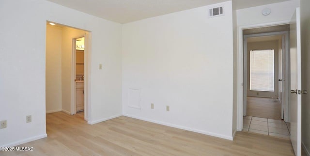 interior space featuring baseboards, visible vents, and light wood-style floors