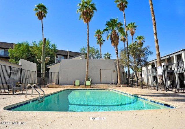 community pool featuring fence and a patio