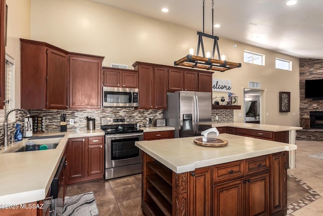 kitchen featuring a towering ceiling, stainless steel appliances, a sink, and light countertops