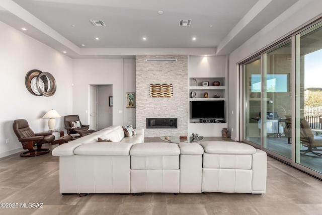 living area featuring a stone fireplace, built in shelves, visible vents, and recessed lighting