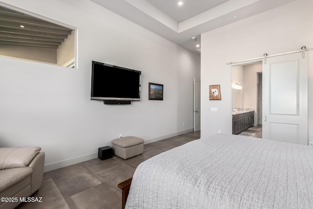 bedroom featuring a barn door, recessed lighting, ensuite bath, and baseboards