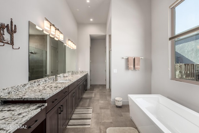 full bath featuring tiled shower, vanity, and a bath