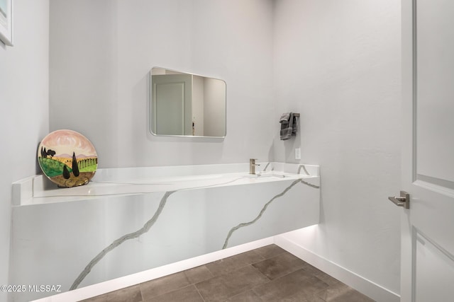 bathroom with a sink and baseboards