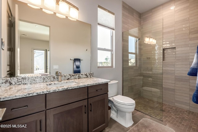 full bathroom with toilet, plenty of natural light, a walk in shower, and vanity