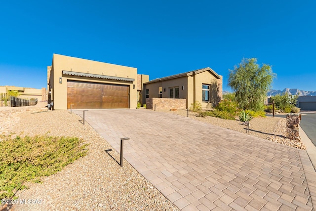 view of front facade featuring a garage, decorative driveway, and stucco siding