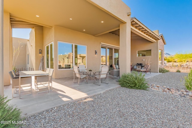 view of patio with outdoor dining space and fence