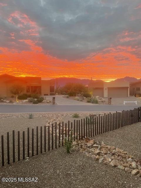 yard at dusk featuring fence and a mountain view