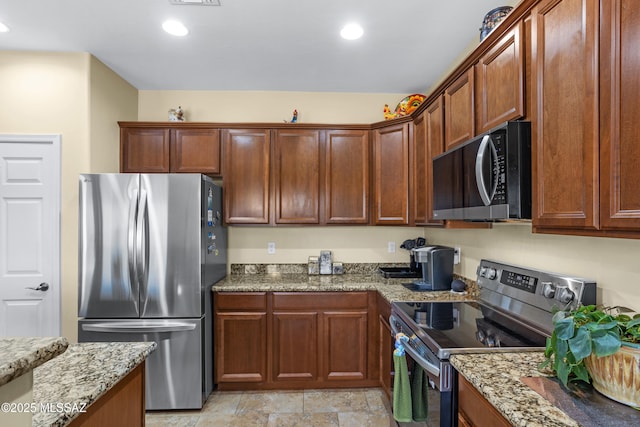 kitchen featuring appliances with stainless steel finishes, recessed lighting, visible vents, and light stone countertops