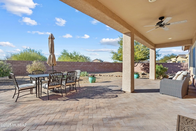 view of patio featuring outdoor dining area, a fenced backyard, and ceiling fan