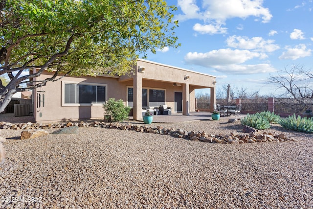 rear view of property with ceiling fan, a patio, central AC unit, and stucco siding