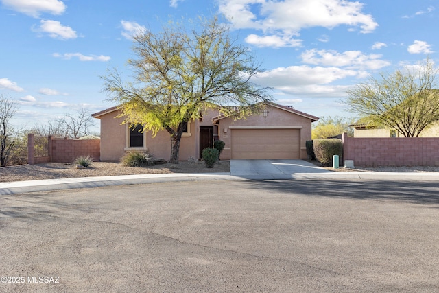 view of front facade with driveway, an attached garage, fence, and stucco siding