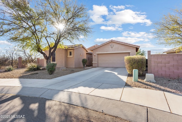 view of front of house with concrete driveway, a tile roof, an attached garage, fence, and stucco siding