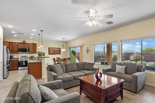 living area featuring baseboards, visible vents, ceiling fan, and recessed lighting