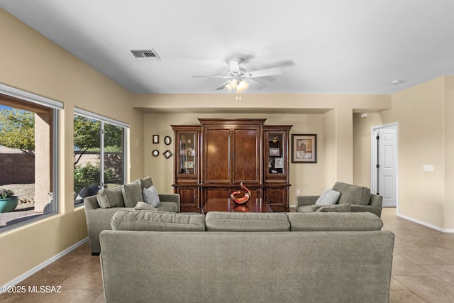 living room featuring light tile patterned floors, baseboards, visible vents, and ceiling fan