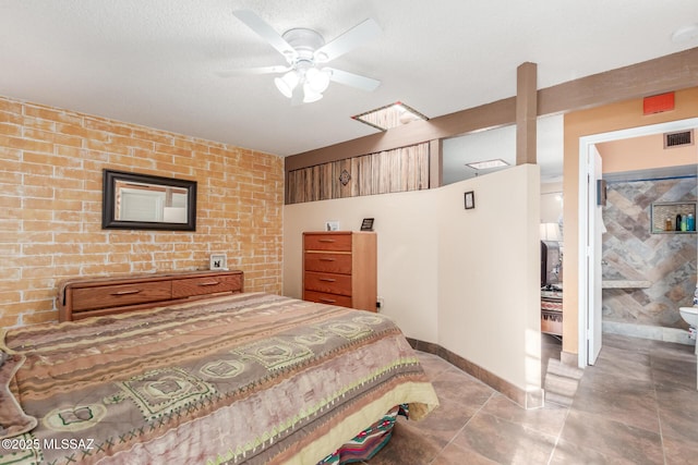 bedroom featuring a ceiling fan, brick wall, visible vents, and baseboards