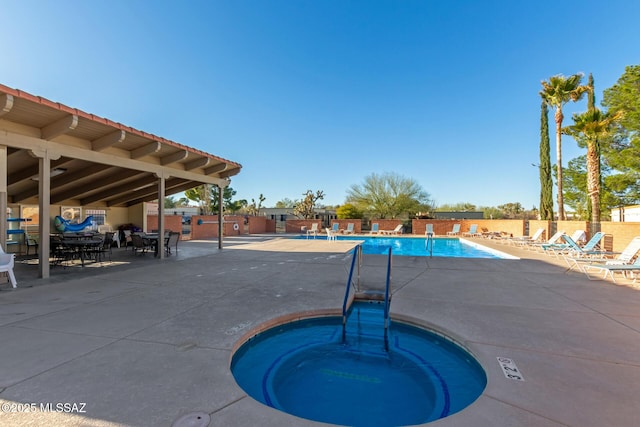 community pool featuring a community hot tub, a patio area, and fence