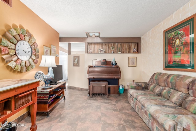 living room featuring visible vents, a textured ceiling, and baseboards