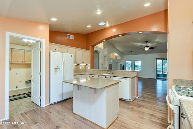 kitchen with visible vents, white cabinets, a kitchen island, white appliances, and a peninsula