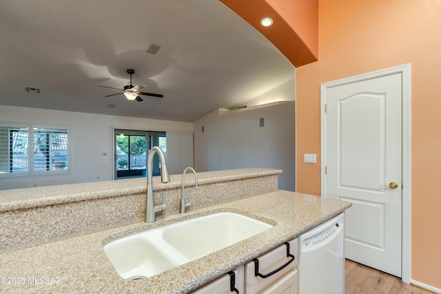 kitchen with white dishwasher, a sink, visible vents, white cabinets, and light stone countertops