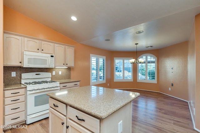 kitchen featuring a chandelier, white appliances, a kitchen island, visible vents, and decorative light fixtures