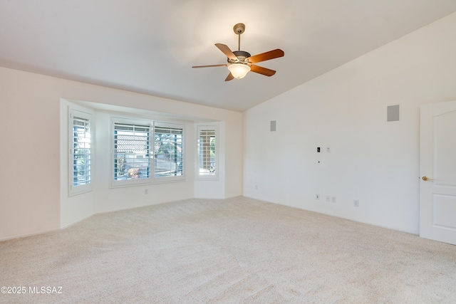 spare room with vaulted ceiling, ceiling fan, light carpet, and visible vents