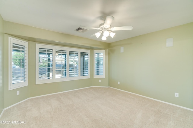 empty room featuring light carpet, baseboards, visible vents, and a ceiling fan